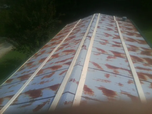 Rusted metal roof panels with new wood purlins before replacement — Storm Damage Roof Repair in Castleford by Roofing Brothers