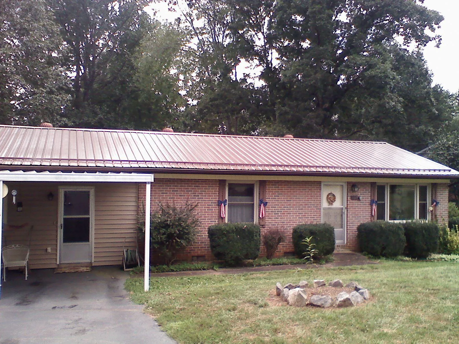 Bronze metal roof and carport on a brick ranch home — Roof Repair work by our crew in Castleford
